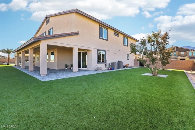 rear view of property with a patio, central AC unit, and a lawn