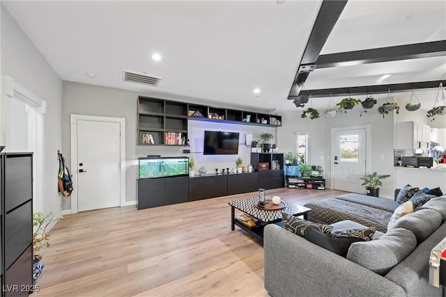 living room with light hardwood / wood-style flooring and beamed ceiling