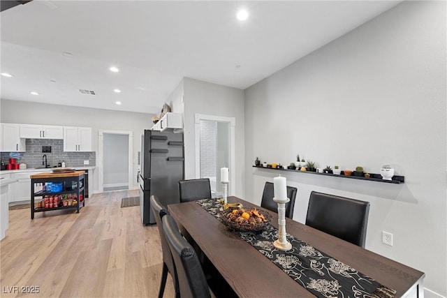 dining room featuring sink and light hardwood / wood-style flooring