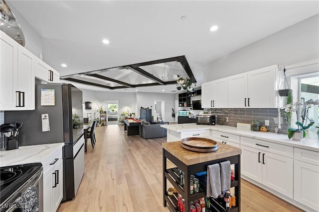 kitchen featuring white cabinetry, stainless steel range with electric stovetop, and light stone countertops