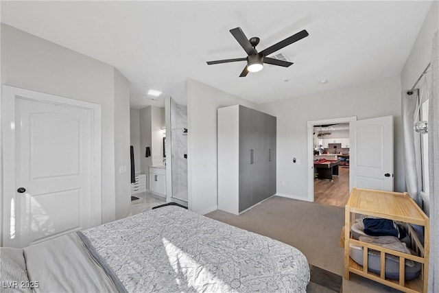 carpeted bedroom with ensuite bath, ceiling fan, and a closet