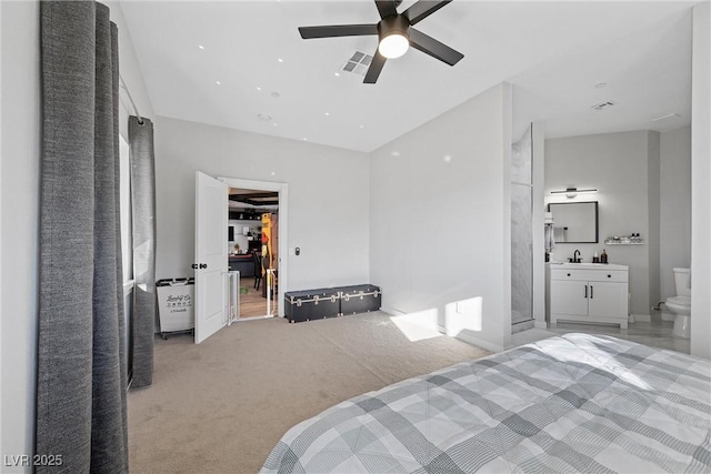 carpeted bedroom with ceiling fan, ensuite bath, and sink