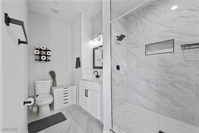 bathroom featuring tiled shower, vanity, and toilet