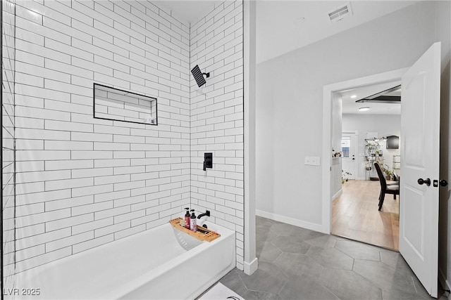 bathroom featuring tiled shower and tile patterned floors