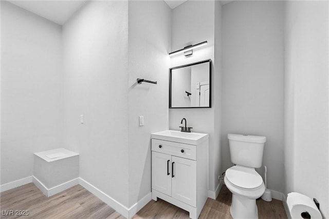 bathroom with toilet, hardwood / wood-style flooring, and vanity