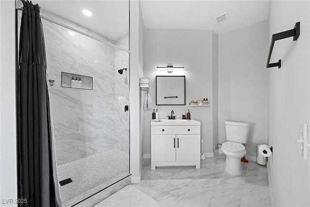 bathroom with a tile shower, vanity, and toilet