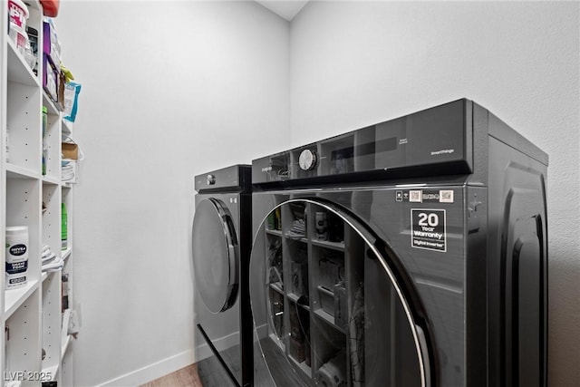 washroom featuring washing machine and clothes dryer and wood-type flooring