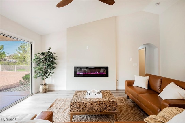 living room with lofted ceiling, hardwood / wood-style floors, and ceiling fan