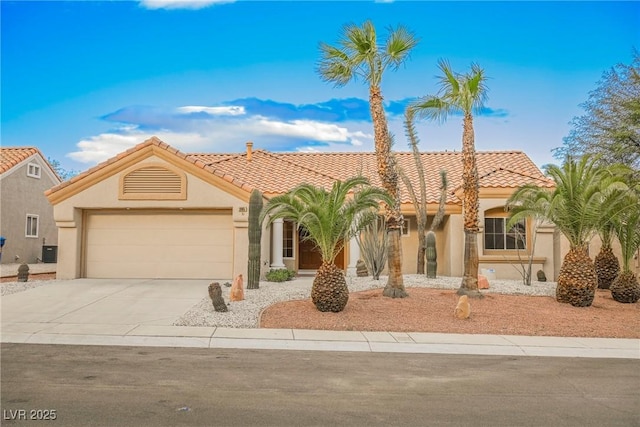 mediterranean / spanish home with central AC unit and a garage