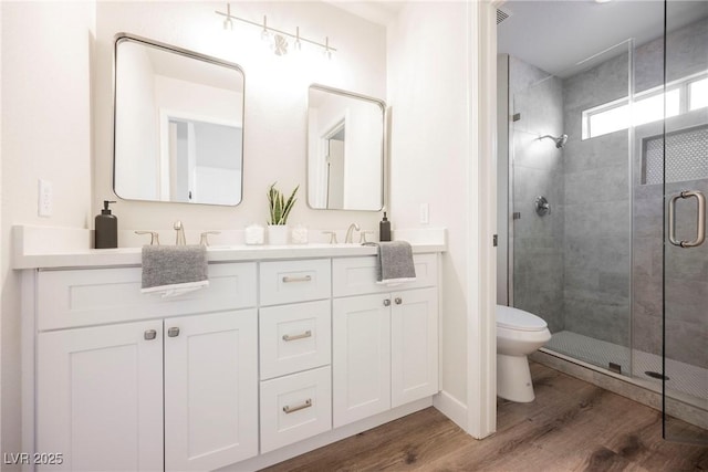 bathroom with toilet, vanity, walk in shower, and hardwood / wood-style floors