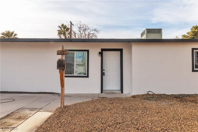 entrance to property featuring a patio and cooling unit