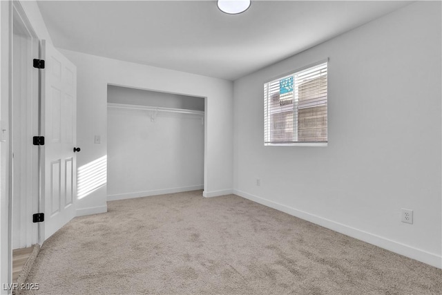 unfurnished bedroom featuring light colored carpet and a closet