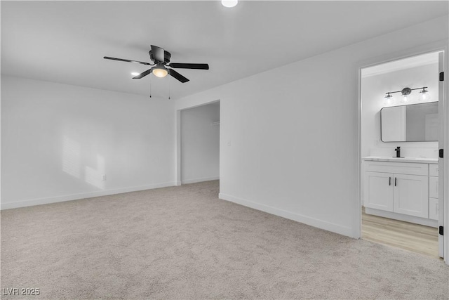 spare room featuring light colored carpet, ceiling fan, and sink