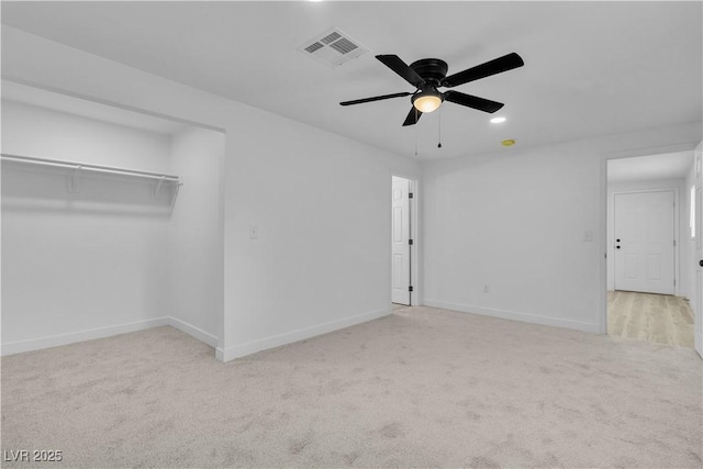 unfurnished bedroom with ceiling fan, light colored carpet, and a closet