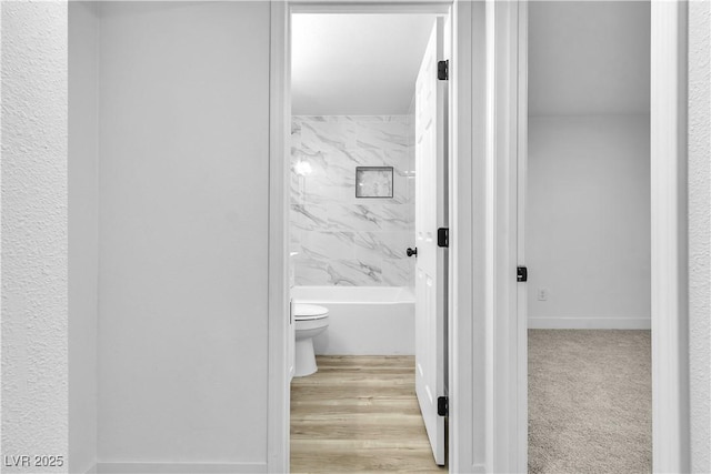 bathroom with toilet and tiled shower / bath