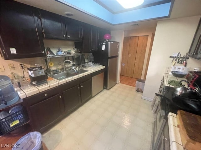 kitchen with sink, stainless steel appliances, and tile countertops