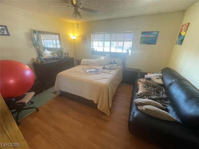 bedroom featuring hardwood / wood-style flooring, a textured ceiling, and ceiling fan