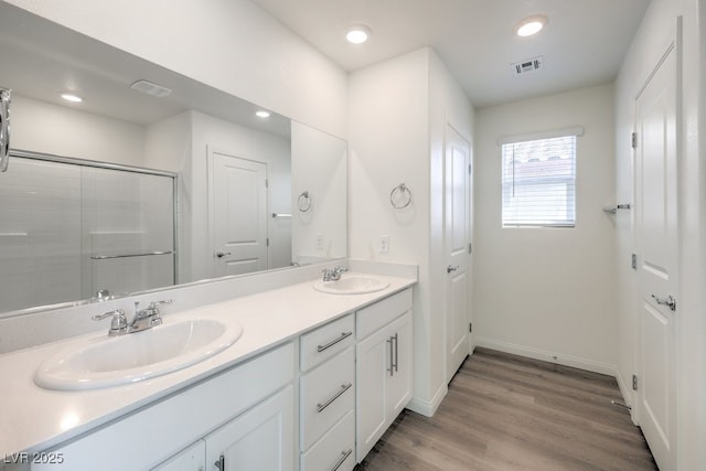 bathroom with an enclosed shower, vanity, and hardwood / wood-style flooring