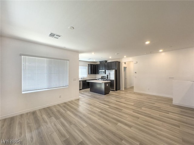 unfurnished living room featuring sink and light wood-type flooring