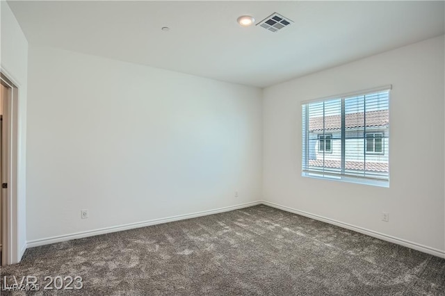 empty room with dark colored carpet