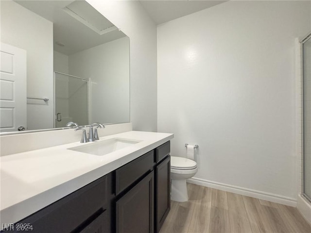 bathroom with toilet, an enclosed shower, vanity, and hardwood / wood-style floors