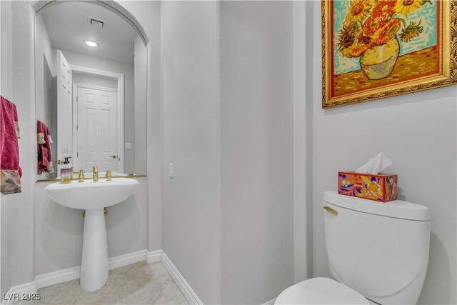 bathroom featuring toilet and tile patterned flooring