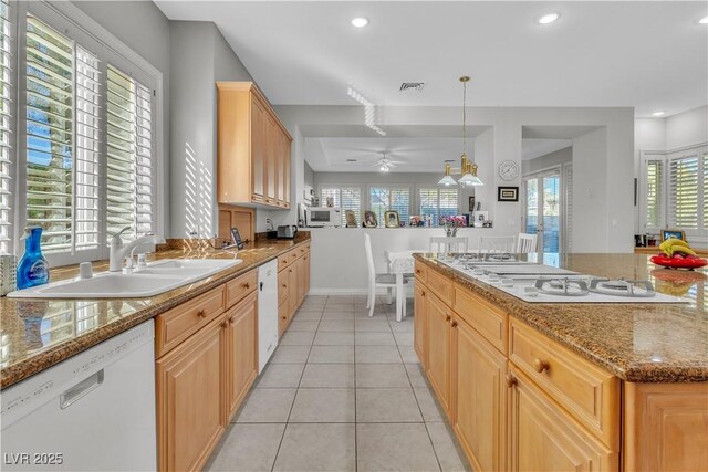 kitchen with white appliances, hanging light fixtures, light brown cabinets, sink, and light tile patterned flooring