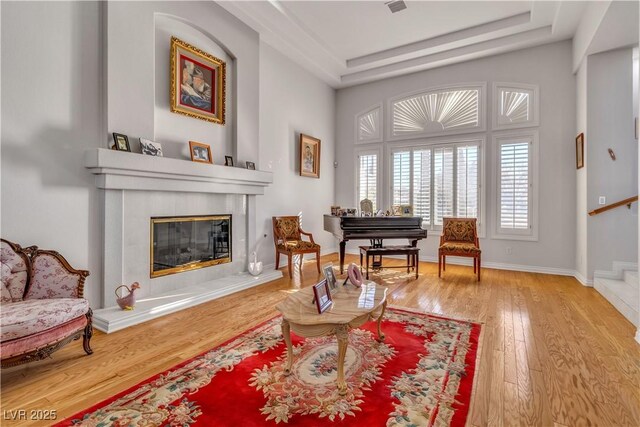 living area with a tile fireplace and hardwood / wood-style flooring