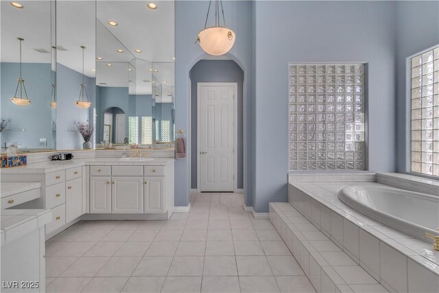 bathroom with tile patterned flooring, a wealth of natural light, and vanity