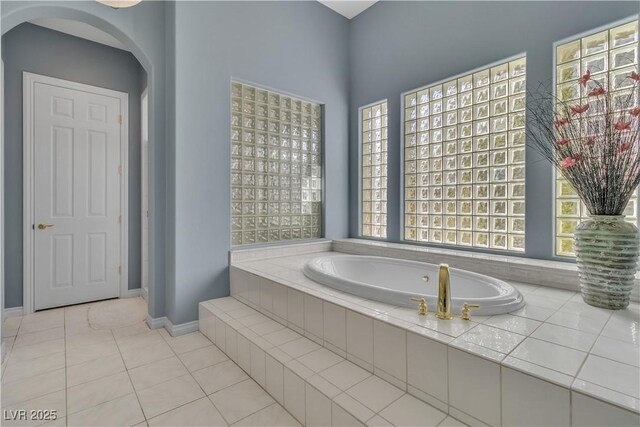 bathroom featuring tile patterned floors and tiled bath