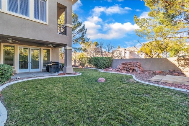 view of yard featuring french doors and ceiling fan