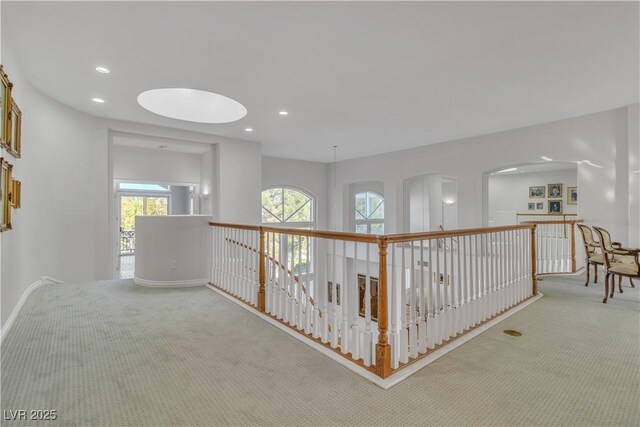 hall with light colored carpet and a wealth of natural light