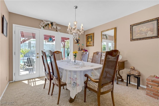 dining space with french doors, a notable chandelier, and light carpet