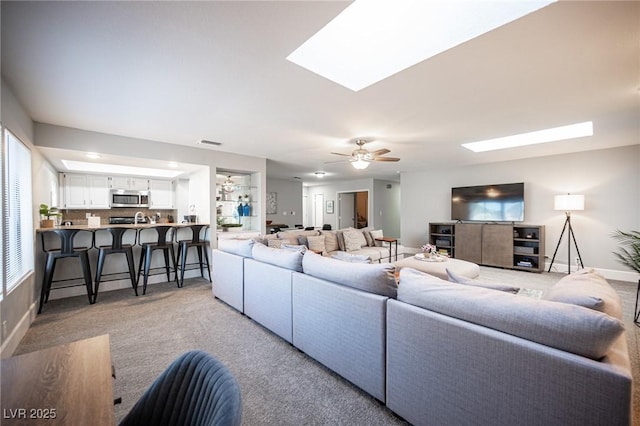 carpeted living room with ceiling fan