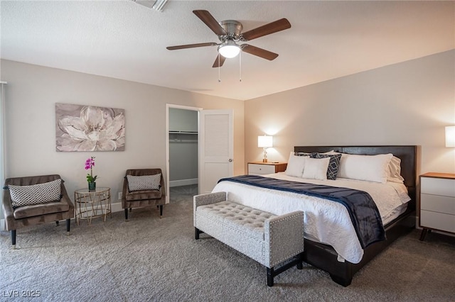 carpeted bedroom with a closet, ceiling fan, and a spacious closet