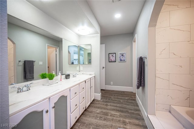 bathroom with a bathing tub, hardwood / wood-style flooring, and vanity