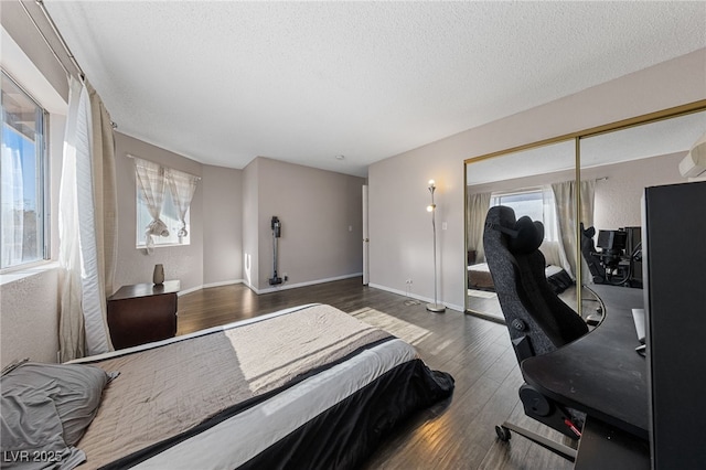 bedroom featuring a closet, a textured ceiling, and dark wood-type flooring