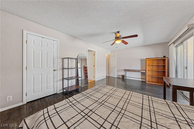 empty room with dark hardwood / wood-style flooring, a textured ceiling, and ceiling fan