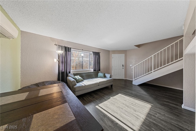 living room with a textured ceiling, a wall mounted air conditioner, and dark hardwood / wood-style floors