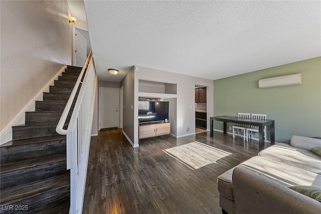 living room featuring dark wood-type flooring, a wall mounted AC, and a textured ceiling