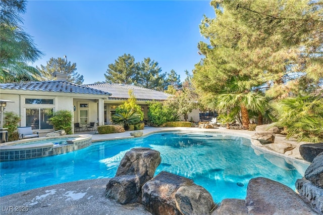 view of swimming pool featuring an in ground hot tub