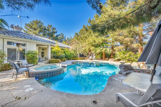 view of swimming pool featuring an in ground hot tub and a patio area