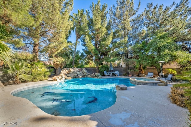 view of swimming pool featuring a patio area and an in ground hot tub