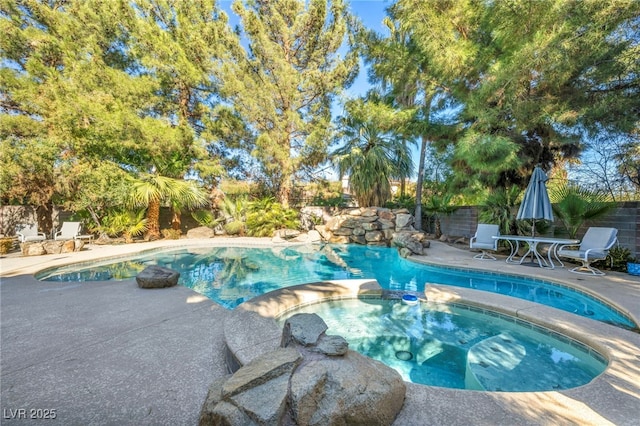 view of pool with a patio and an in ground hot tub