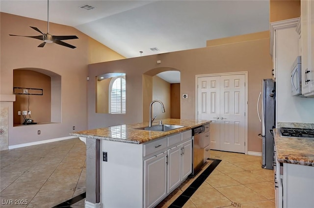 kitchen featuring sink, stainless steel appliances, white cabinetry, light tile patterned floors, and an island with sink