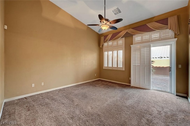 carpeted spare room with ceiling fan, vaulted ceiling, and plenty of natural light