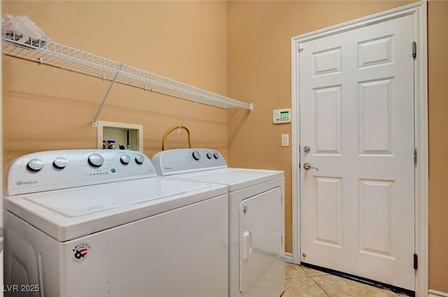 laundry room with washing machine and dryer and light tile patterned floors