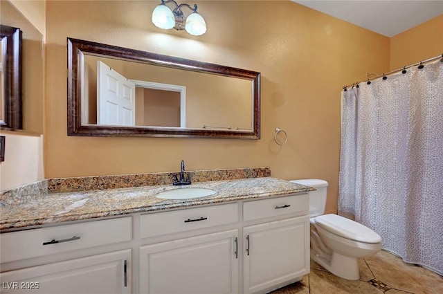 bathroom featuring toilet, vanity, and tile patterned flooring