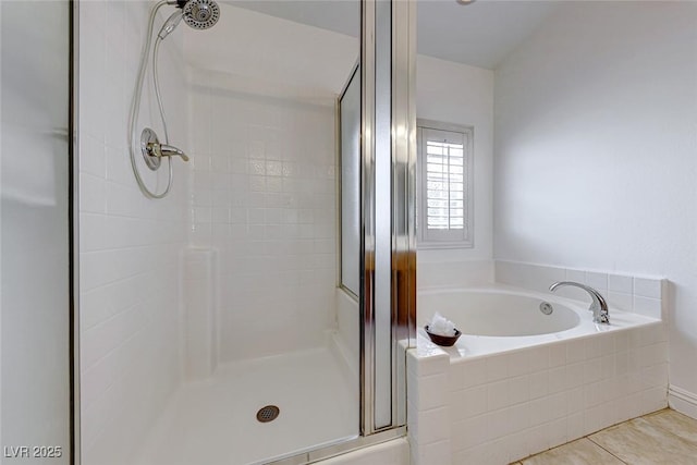 bathroom with separate shower and tub and tile patterned floors