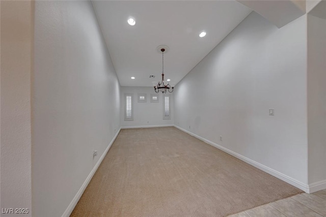 tiled empty room featuring a chandelier